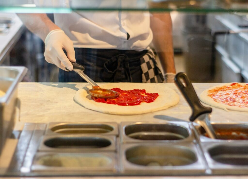 restaurant staff serving pizza to table
